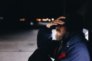 man sitting at the shed beside the street