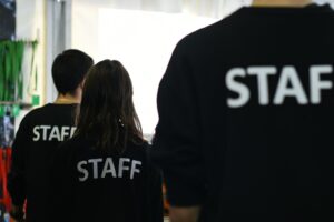 a group of people in black shirts standing in a room