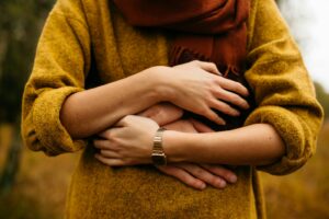 Person in yellow jumper being hugged