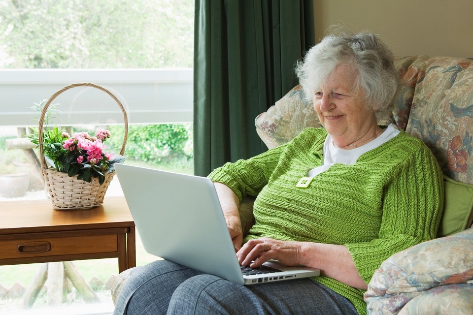 An older woman using a laptop in her own home