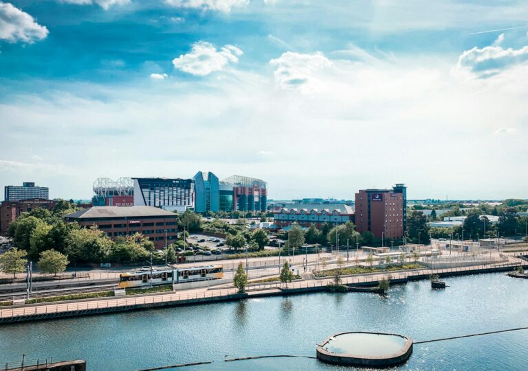 white boat on water near city buildings during daytime