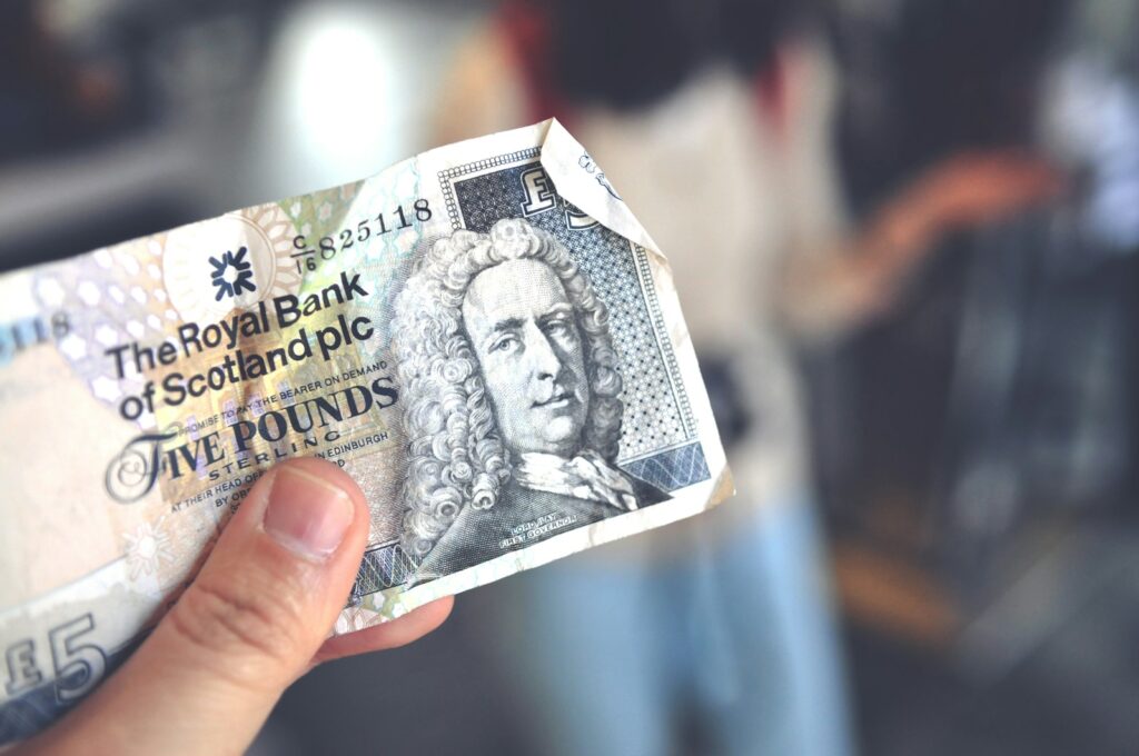 person holding Royal Bank of Scotland plc £5 note