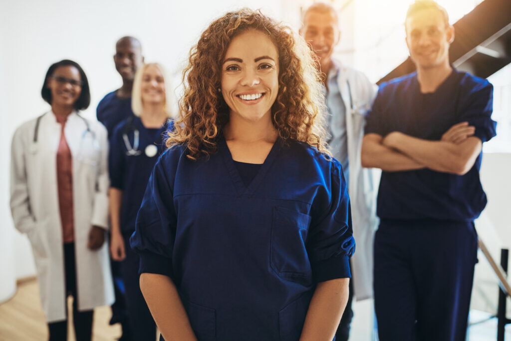 Smiling female doctor standing with medical colleagues in a hosp