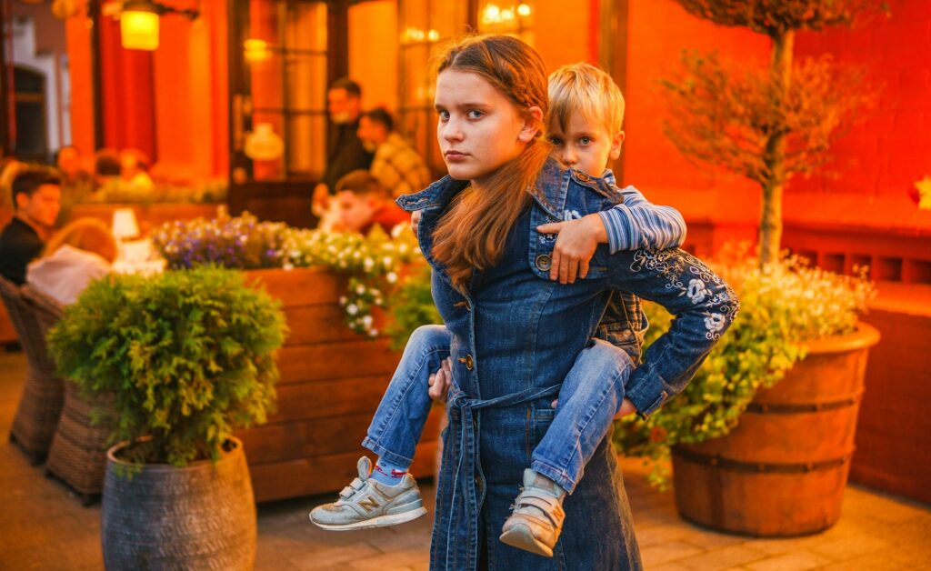 girl in blue denim jeans sitting on brown wooden seat