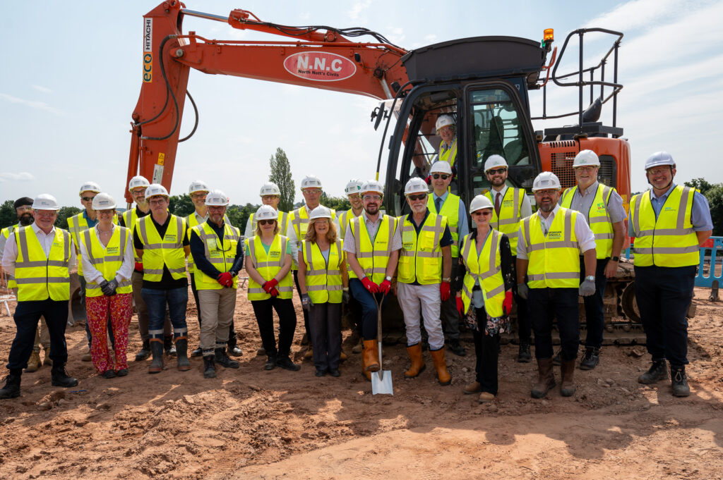 Councillors and project partners - in hi-vis jackets and hard jackets - stand in front of a digger at the site of the new school being built in Mansfield, Nottinghamshire