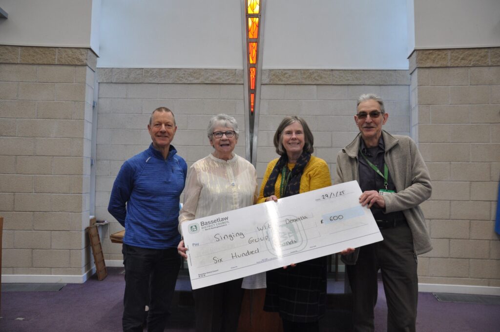 The team at Singing with Dementia in Worksop receive a cheque from the district council for £600