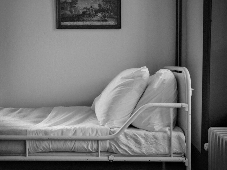 a single bed in a small room with a painting on the wall