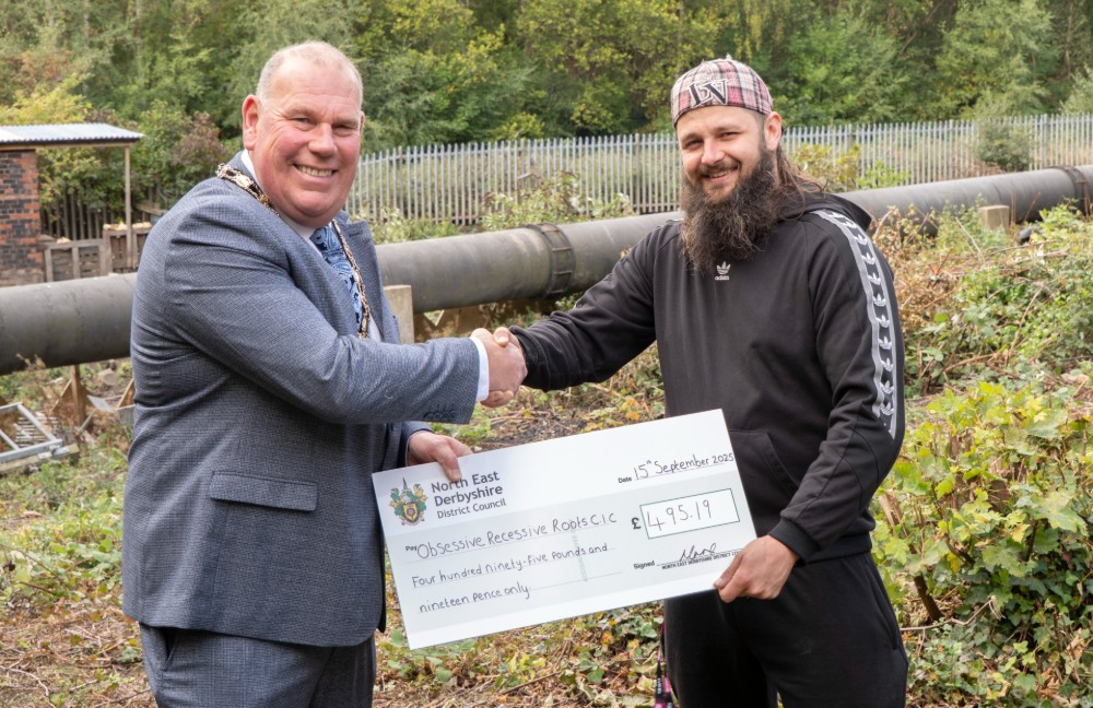 Cllr Hartshorne, Chair of North East Derbyshire District Council, presents Shay Tipler with a cheque to support Pig Pals