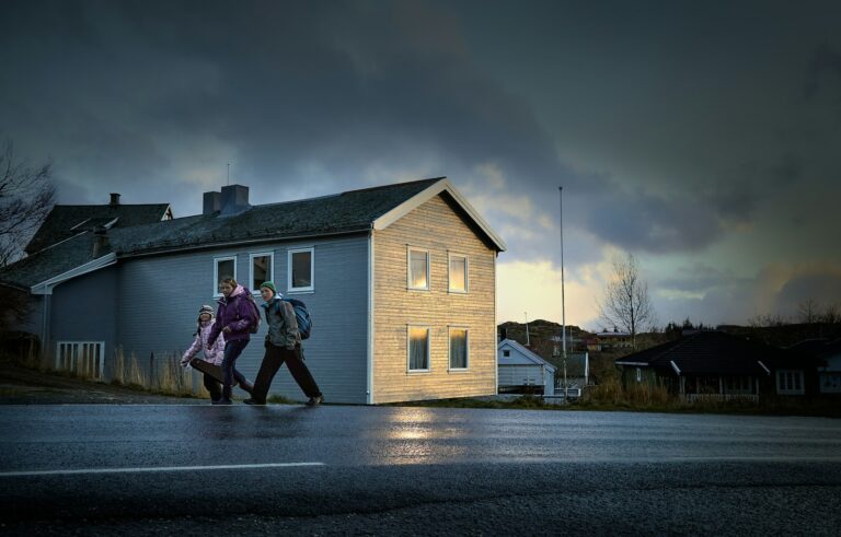 A couple of people walking across a street