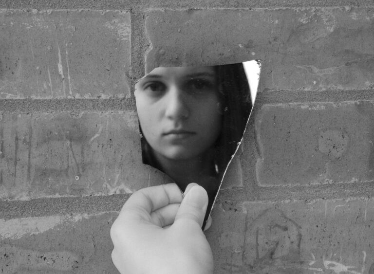 a woman leaning against a brick wall