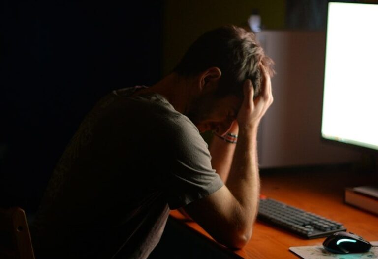 a man sitting at a desk in front of a computer
